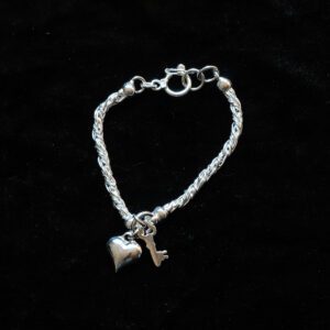 A picture of a bracelet with a heart and key design