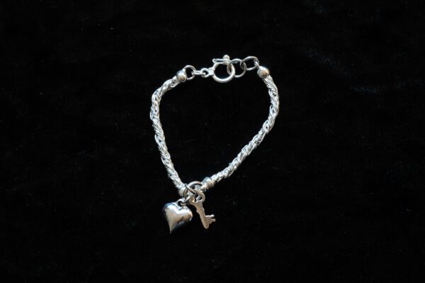 A picture of a bracelet with a heart and key design